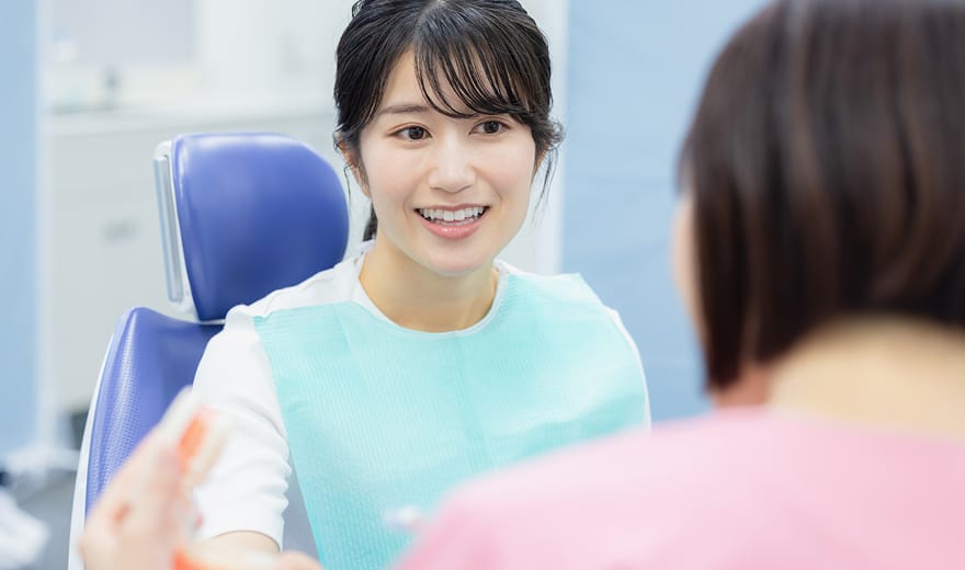 歯科衛生士の説明を受ける女性