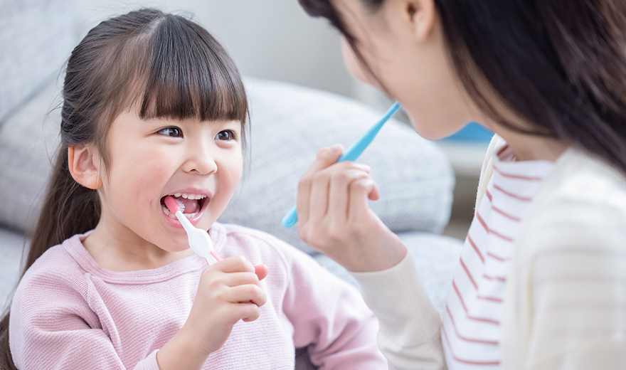 親子で歯磨きをする写真