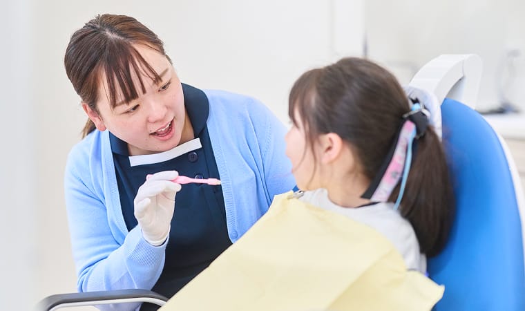 子供の歯並びを確認する歯科衛生士