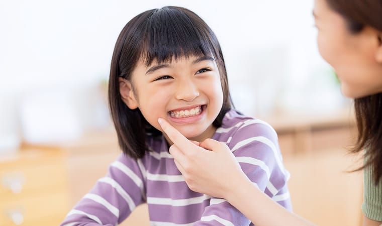 子供の歯並びを確認する親子